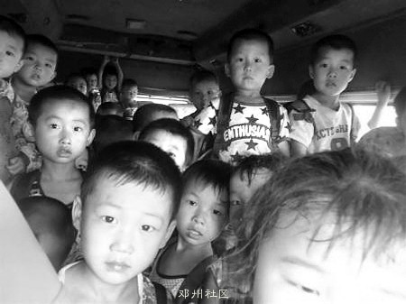 许多孩子被挤得只能手扶车顶站立座上